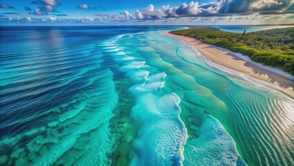 Fototapeta premium Breathtaking high-angle aerial shot of serene turquoise ocean water with intricate waves and ripples, revealing majestic underwater sand patterns.