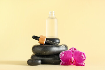 Bottle of essential oil, spa stones and orchid flower on color background