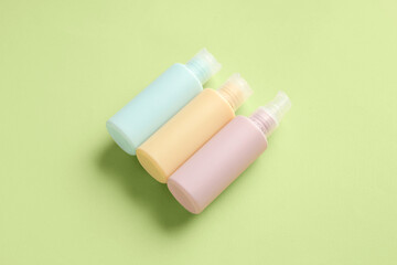 Set of travel cosmetic bottles on color background
