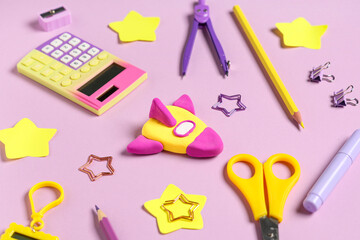 Rocket made of plasticine with stationery on lilac background. Top view