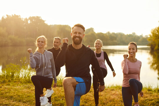 Portrait of a happy group of people exercising and doing sports and workout in a city park. Outdoor fitness activities, highlighting the team commitment to staying active and healthy.