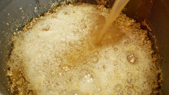 Mashing malt and maintaining temperature pauses during the preparation of homemade beer close-up