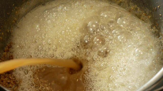 Mashing malt and maintaining temperature pauses during the preparation of homemade beer close-up