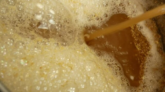 Mashing malt and maintaining temperature pauses during the preparation of homemade beer close-up