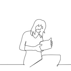 woman inspecting product packaging holding with both hands, shopping cart nearby - one line art vector. the concept buyer in a supermarket