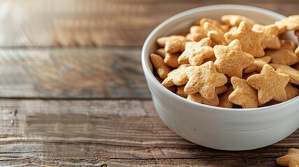 Fototapeta premium A bowl of frosted animal crackers on a wooden background, evoking a rustic feel.