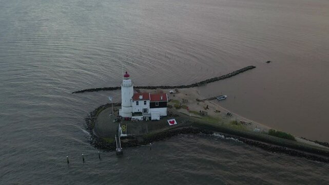 Aerial view of serene coast with historic lighthouse and Paard van Marken, Marken, Netherlands.