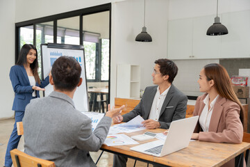 Asian business presents to explain the graph work on the whiteboard. Consulting, discussing, exchanging knowledge.