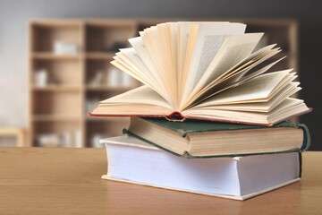 stack of books in library on wooden table