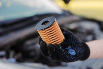 Auto mechanic holds an oil filter for gasoline cars in his hand. Oil change.