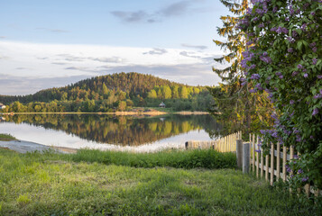 A beautiful lake with a fence and a house in the background