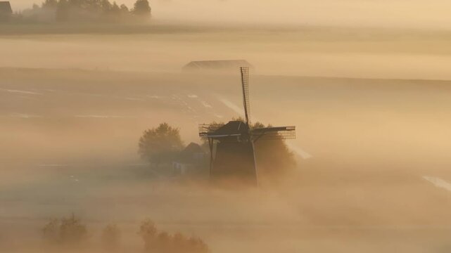 Aerial view of traditional Windmill in foggy sunrise, Workum, Netherlands.