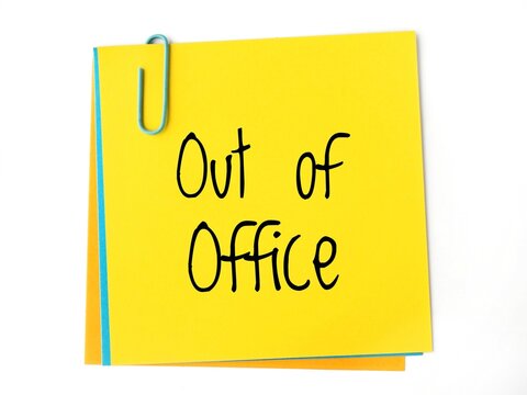 A yellow sticky note with the handwritten text Out of office in black letters. Is it correct: out-of-office message on a paper note