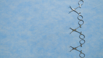 Stainless medical towel clamps placed on blue background.Towel clamps are mounting clamps with a pointed end to hold the ends of the towel or doek in place. Medical instrumets used in surgery.