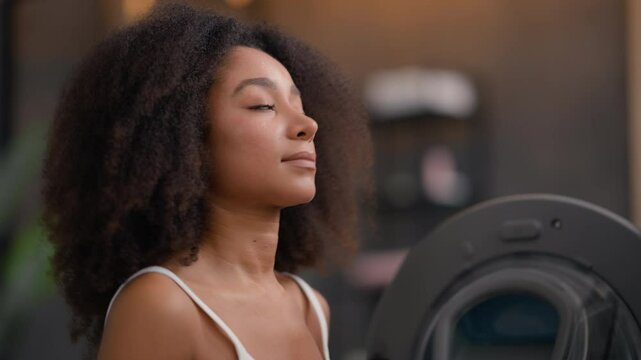 African American woman girl female smiling positive lady housework housekeeping housewife homeowner open door washing machine laundry smelling sniff good smell aroma soft fresh white towel hug gel