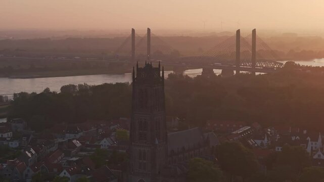 Aerial view of Sint-Maartenskerk, bridge, vessel, and river at sunrise, Zaltbommel, Netherlands.