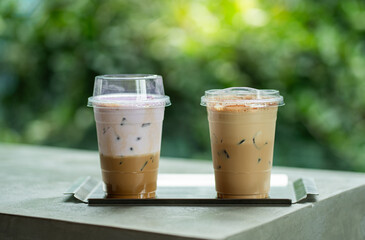 Close up glass of ice coffee with taro milk and ice cappucino  on raw cement table of a coffee shop summer terrace, menu photography.