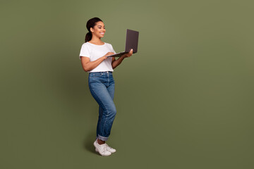 Photo portrait of cheerful young girl working freelancer using laptop spreadsheets data analytic isolated on khaki color background