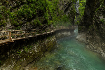 Vintgar Gorges Park a few km from Lake Bled, Slovenia. Wooden walkways accompany the path above the river rapids and waterfalls. River hits rocks and creates fog.Adventure family holidays. Freshness.