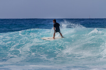 Tenerife, Spain 02 11 2013: Young man bodyboarding on a big wave with white foam. Blue sky. Surfing day. Atlantic Ocean. Tenerife, Canary Islands, Spain.