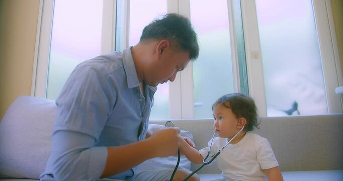 cute small child and father game as Doctor holding Stethoscope listening to father patient pretending nurse having fun with dad in cozy living room at home, capturing a heartwarming family moment.