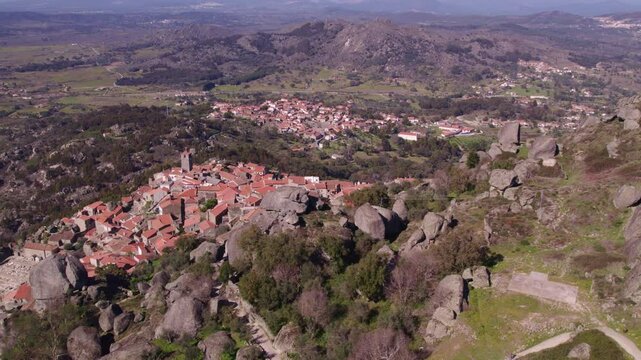 Aerial view of medieval castle ruins amidst mountains and rocks at sunrise, Monsanto, Castelo Branco, Portugal.