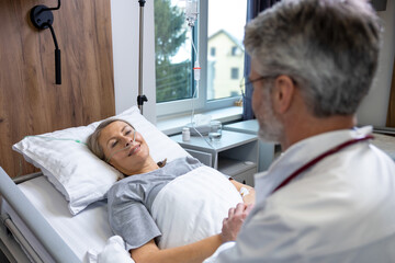 Fototapeta premium Doctor talking to a patient and holding her hands