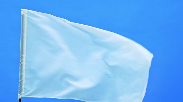 Slow motion video of white flag waving on blue background