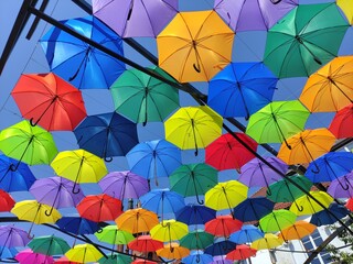 Multi-colored umbrellas against the sky, background texture