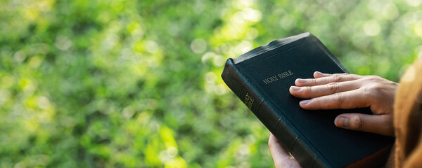 Bible concept and prayers of thanksgiving from God. Therapeutic living in peace with nature while spending time with God. Young woman praying with the Words of God