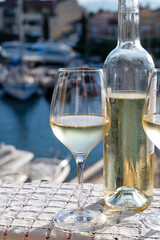 Glasses of cold white Cote de Provence wine in yacht harbour of Port Grimaud, summer vacation on French Riviera in Provence, France, wine tasting