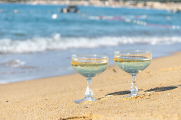 Summer time on French Riviera, two coupe glasses of champagne cremant sparkling wine on Pampelonne sandy beach near Saint-Tropez in sunny day, Var, vacation in France