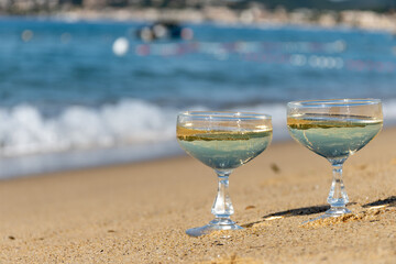Summer time on French Riviera, two coupe glasses of champagne cremant sparkling wine on Pampelonne sandy beach near Saint-Tropez in sunny day, Var, vacation in France