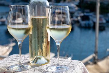 Glasses of cold white Cote de Provence wine in yacht harbour of Port Grimaud, summer vacation on French Riviera in Provence, France, wine tasting