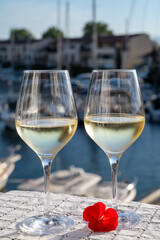 Glasses of cold white Cote de Provence wine in yacht harbour of Port Grimaud, summer vacation on French Riviera in Provence, France, wine tasting