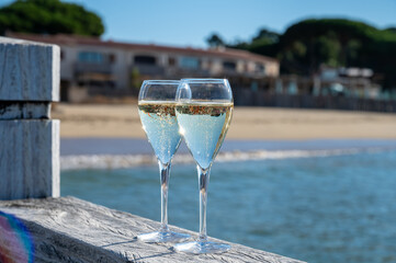 Summer time in Provence, two glasses of cold champagne cremant sparkling wine on famous Pampelonne sandy beach near Saint-Tropez in sunny day, Var department, France, beach club party