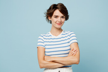Young smiling cheerful woman wearing striped t-shirt casual clothes hold hands crossed folded look...