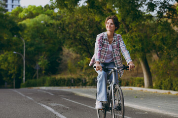 Full body young happy fun smiling woman wearing checkered shirt casual clothes look aside walk...