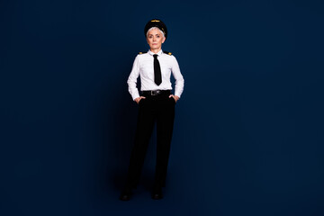 Full length photo of lovely pensioner lady professional commercial pilot dressed aviator uniform isolated on dark blue color background © deagreez