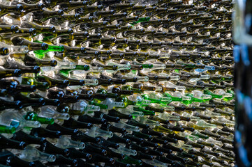 Obraz premium Wine bottles in a row on a stone wall. Close-up