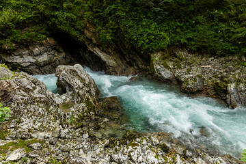 Vintgar Gorges Park a few km from Lake Bled, Slovenia. Wooden walkways accompany the path above the river rapids and waterfalls. River hits rocks and creates fog.Adventure family holidays. Freshness.