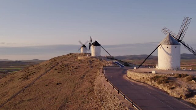 Aerial view of traditional windmills and castle at sunrise, Consuegra, Spain.