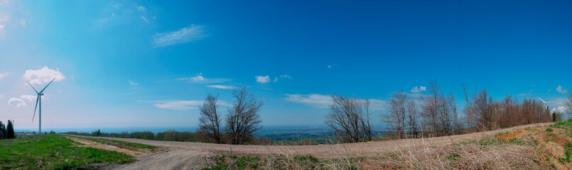 Wind turbine for alternative energy in mountain landscape with clear space background. The concept of clean energy, eco-energetics of the wind.