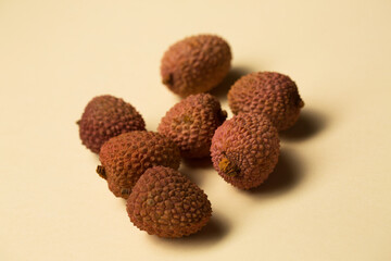 Small tropical lychee berries on a sand-colored background
