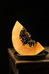 Sliced ​​papaya in a ceramic bowl in a minimalist style, low key