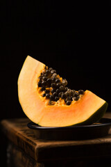 Sliced ​​papaya in a bowl in a minimalist style, low key