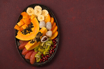 A large plate with sliced ​​various fruits on a metal vintage plate