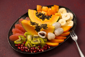 A plate with ​​various tropical fruits on a metal vintage plate