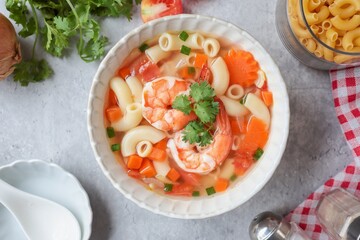 Home made macaroni with shrimp or pasta soup in a white ceramic bowl , top view food table