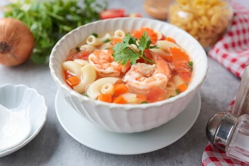 Home made macaroni with shrimp or pasta soup in a white ceramic bowl , top view food table
